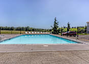 Thumbnail 53 of 72 - A large outdoor swimming pool surrounded by a fence at Riverplace Apartment Homes, Independence