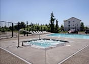 Thumbnail 56 of 72 - A small pool with a slide and a house in the background at Riverplace Apartment Homes, Independence, OR, 97351