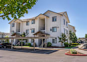 Thumbnail 63 of 72 - A large white apartment building with a parking lot in front at Riverplace Apartment Homes, Oregon