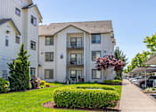 Thumbnail 68 of 72 - A white apartment building with a green lawn in front at Riverplace Apartment Homes, Independence, OR, 97351