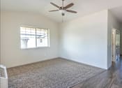 Thumbnail 12 of 28 - A room with a ceiling fan and a window at Silverplace Apartment Homes, Oregon