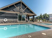 Thumbnail 16 of 28 - A pool with a house in the background at Silverplace Apartment Homes, Silverton
