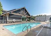 Thumbnail 17 of 28 - A pool with a slide and a house behind it at Silverplace Apartment Homes, Silverton, 97381