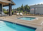 Thumbnail 18 of 28 - A pool surrounded by a black fence with a warning sign on it at Silverplace Apartment Homes, Silverton, Oregon