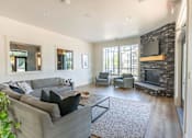 Thumbnail 19 of 28 - A living room with a grey couch and a stone fireplace at Silverplace Apartment Homes, Silverton, 97381