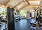 Thumbnail 23 of 28 - A gym with a row of treadmills and a weight rack at Silverplace Apartment Homes, Silverton, OR