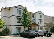 Thumbnail 25 of 28 - A row of cars parked in front of a building at Silverplace Apartment Homes, Oregon