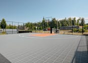 Thumbnail 26 of 28 - A basketball court is surrounded by a fence and has a net in the middle at Silverplace Apartment Homes, Silverton, Oregon