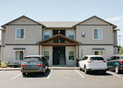 Thumbnail 27 of 28 - A grey building with a car parked in front at Silverplace Apartment Homes, Silverton, OR, 97381