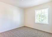Thumbnail 3 of 28 - A room with a window and carpeted floor at Silverplace Apartment Homes, Oregon, 97381