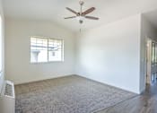 Thumbnail 7 of 28 - A room with a ceiling fan and a window at Silverplace Apartment Homes, Silverton, OR
