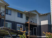 Thumbnail 12 of 22 - Apartment building with balconies and flower pots at St Helens Place Apartment Homes, Oregon