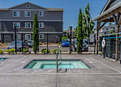 Thumbnail 3 of 22 - A swimming pool in a backyard with a building in the background. at St Helens Place Apartment Homes, St Helens, OR
