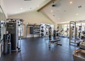 Thumbnail 5 of 22 - A spacious gym with various exercise equipment and a bench at St Helens Place Apartment Homes, St Helens, 97051