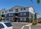 Thumbnail 6 of 22 - A large, modern building with a parking lot in front at St Helens Place Apartment Homes, St Helens, OR, 97051