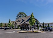 Thumbnail 7 of 22 - A building with a green roof and a parking lot in front. at St Helens Place Apartment Homes, St Helens, 97051