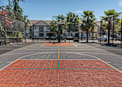 Thumbnail 11 of 46 - A basketball court with a red surface and a basketball hoop in the middle at Stoneplace Apartment Homes, Molalla, OR