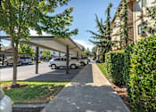 Thumbnail 13 of 46 - A tree-lined street with cars parked on the side at Stoneplace Apartment Homes, Oregon, 97038