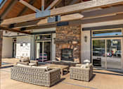 Thumbnail 2 of 46 - A patio with a fireplace and seating area at Stoneplace Apartment Homes, Molalla, OR