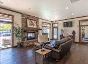 Thumbnail 3 of 46 - A living room with a stone fireplace and a flat screen TV mounted on the wall at Stoneplace Apartment Homes, Molalla, OR