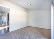 Thumbnail 36 of 46 - A large, empty room with a carpeted floor and white walls at Stoneplace Apartment Homes, Molalla, 97038