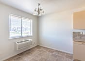 Thumbnail 41 of 46 - A room with a window, tiled floor, and a chandelier at Stoneplace Apartment Homes, Molalla, Oregon