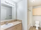 Thumbnail 42 of 46 - A bathroom with a sink, mirror, toilet and cabinetry at Stoneplace Apartment Homes, Oregon