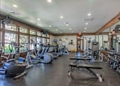 Thumbnail 6 of 46 - A spacious gym with a variety of equipment including treadmills, weights, and exercise machines at Stoneplace Apartment Homes, Molalla, 97038