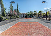 Thumbnail 9 of 46 - A tennis court with a net and a building in the background at Stoneplace Apartment Homes, Molalla, 97038