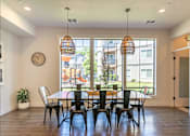 Thumbnail 1 of 12 - A dining room with a table and chairs and a clock on the wall at Timberridge Place Apartment Homes, Albany, Oregon