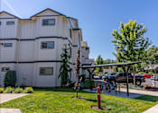 Thumbnail 11 of 12 - A white apartment building with a green lawn in front at Timberridge Place Apartment Homes, Albany