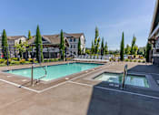 Thumbnail 5 of 12 - A large outdoor swimming pool with a slide and a hot tub at Timberridge Place Apartment Homes, Oregon, 97322