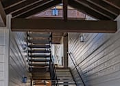 Thumbnail 15 of 49 - A staircase with a metal railing and wooden steps at Woodburn Place Apartment Homes, Woodburn, Oregon