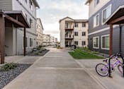 Thumbnail 3 of 49 - A bicycle is parked on a sidewalk in a residential area at Woodburn Place Apartment Homes, Oregon, 97071