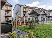 Thumbnail 1 of 49 - A residential area with houses and a playground at Woodburn Place Apartment Homes, Woodburn, OR