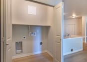 Thumbnail 45 of 49 - A small white kitchen with a sink and a refrigerator at Woodburn Place Apartment Homes, Woodburn, OR, 97071
