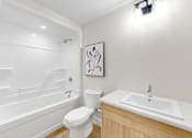 Thumbnail 24 of 24 - A white bathroom with a toilet, sink, and bathtub.