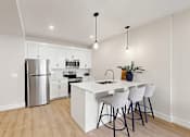 Thumbnail 11 of 24 - A modern kitchen with white cabinets and a white island.
