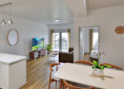 Thumbnail 9 of 24 - A modern kitchen with white cabinets and a wooden table.