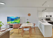 Thumbnail 8 of 24 - A modern kitchen with a dining table and chairs.