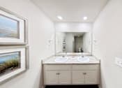 Thumbnail 5 of 13 - A bathroom with a double sink vanity and a large mirror.