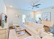 Thumbnail 8 of 13 - A living room with a white couch, a wooden cabinet, and a ceiling fan.