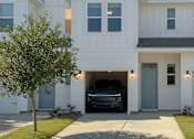 Thumbnail 10 of 13 - A white house with a black truck in the garage.