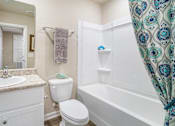 Thumbnail 3 of 9 - A white bathroom with a white toilet, sink, and bathtub.
