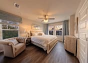 Thumbnail 1 of 13 - A bedroom with a large bed and a couch.