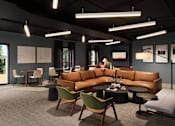 Thumbnail 4 of 8 - A modern living room with a brown leather sofa and green chairs.