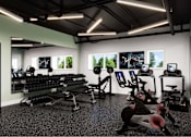 Thumbnail 3 of 8 - A gym with a row of treadmills and elliptical machines.