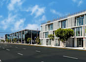 Thumbnail 9 of 9 - A modern building with a glass facade is situated on a street with a clear blue sky above.