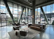 Thumbnail 8 of 16 - A large room with a couch, chairs, and tables with a view of the outside.