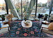 Thumbnail 3 of 16 - A room with a glass wall and a rug with a floral pattern.